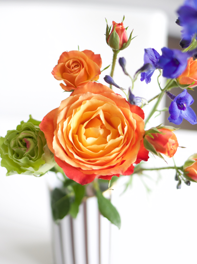 Vase with orange, purple and green roses