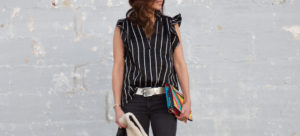 Wearing black Sandro top with ruffle trim and white stripes.
